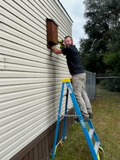 Sustainability Manager Chad Carwein hanging a bat house