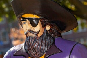 The face of a pirate statue with a hat, eyepatch, and black beard