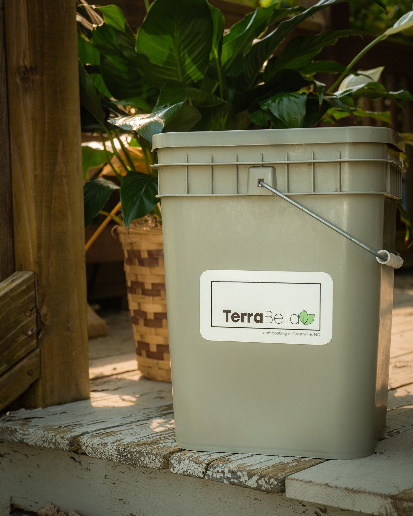 a bucket with a lid that has a sticker on the side with the company name and logo for Terra Bella compost.