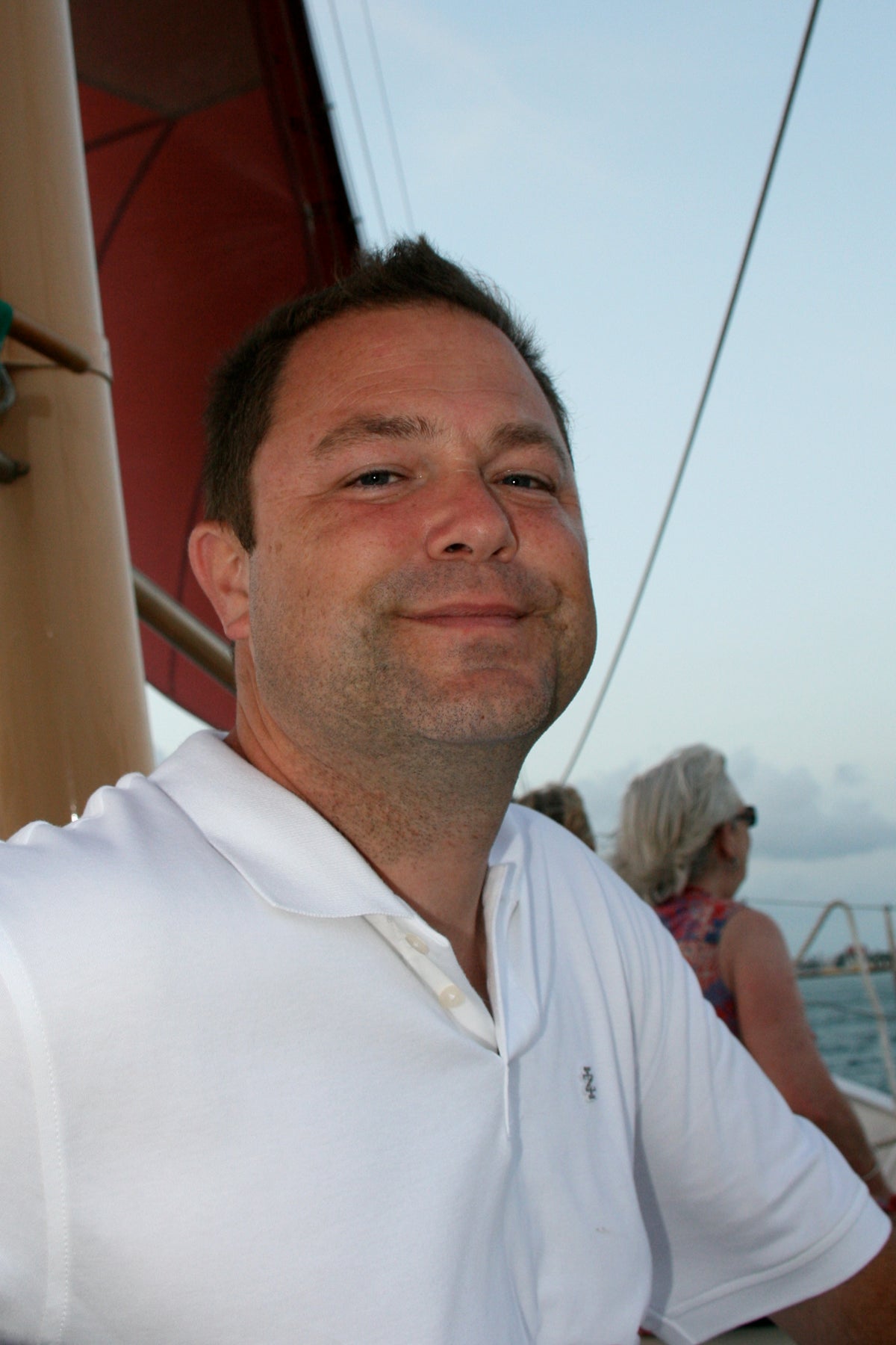 Terry Little, a man in a white polo, smiles at the camera