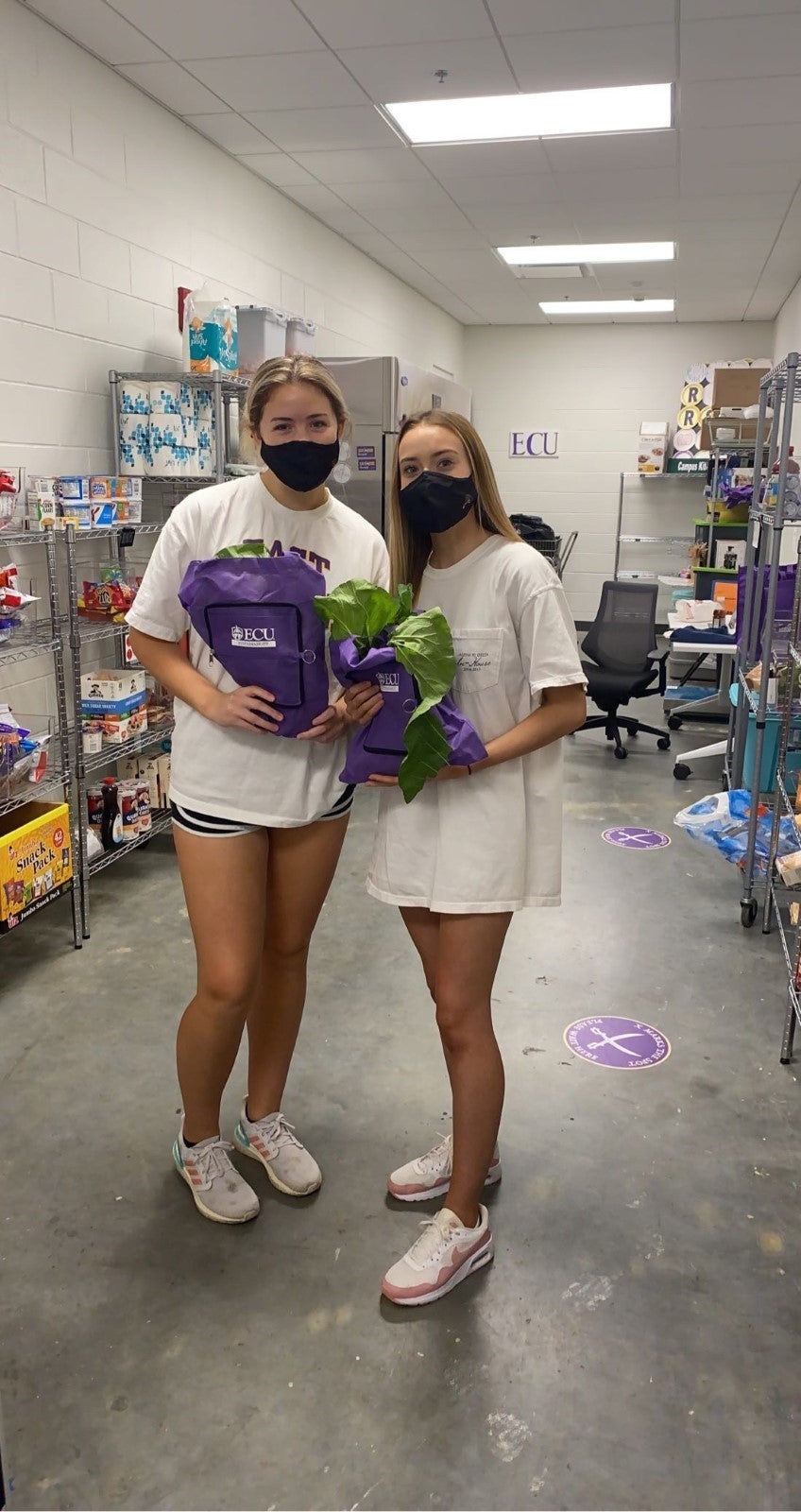 Two girls standing with plants