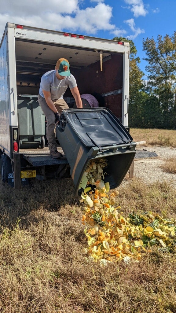 Man dumping compost into garden